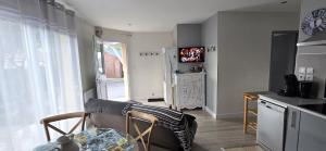 a living room with a couch and a kitchen at WELCOME Logement avec terrasse proche Bordeaux in Saint-André-de-Cubzac