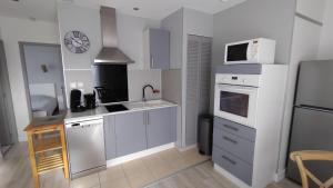 a kitchen with white cabinets and a sink and a microwave at WELCOME Logement avec terrasse proche Bordeaux in Saint-André-de-Cubzac +19 photos