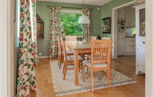 a kitchen and dining room with a wooden table and chairs at Lovely Home In Båstad With Sauna in Båstad