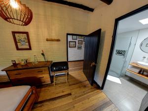 a bedroom with a bed and a desk and a door at Eco Hotel Hacienda El Diamante in Buga