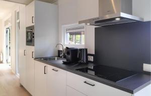 a kitchen with white cabinets and a black counter top at 2 Bedroom Nice Home In Hellendoorn in Hellendoorn