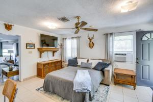 Un dormitorio con una cama y un ventilador de techo. en Pet-Friendly Fort McCoy Cabin with Fire Pit!, en Orange Springs