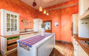 a kitchen with orange walls and a counter top at Beautiful Home In Saint-Cyr-Sur-Loire in Saint-Cyr-sur-Loire
