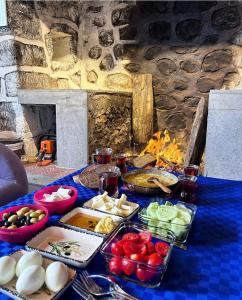 a table with food on it with a fireplace at Amiras Dağevi in Fındıklı +19 photos