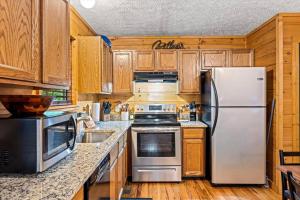 セバービルにあるPrivate, Hot Tub, Arcade, Pups OK, Dollywoodのキッチン(白い冷蔵庫、木製キャビネット付)