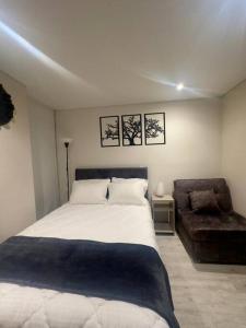 una camera da letto con un letto grande e una sedia di Apartaestudio Encanto y Elegancia Corferias a Bogotá