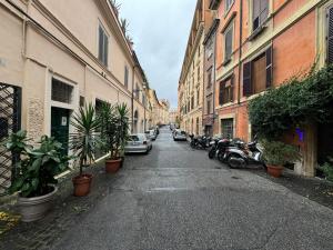 an alley with parked cars and motorcycles on a street at Le Due Torri in Rione Monti in Rome