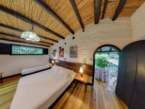 a large bedroom with a large white bed in a room at Eco Hotel Hacienda El Diamante in Buga