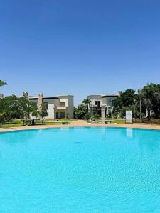 a large blue swimming pool in front of a building at Villa - Royal Golf de Fez - Pool in Fez