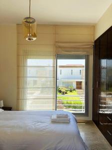 a bedroom with a bed and a large window at Villa - Royal Golf de Fez - Pool in Fez