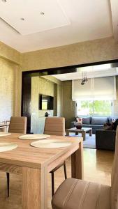 a dining room with a table and a living room at Villa - Royal Golf de Fez - Pool in Fez