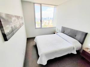 a bedroom with a white bed and a window at Luxury Polanco Apartment With Private Balcony in Mexico City +45 photos
