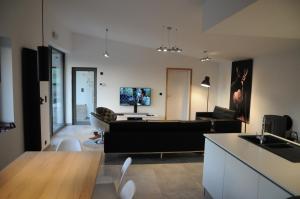 a living room with a black couch and a table at Ard'cube in Noiseux