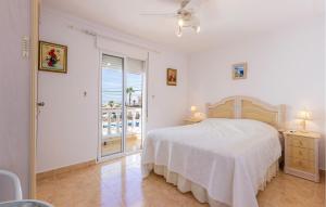 a white bedroom with a bed and a balcony at 3 Bedroom Beautiful Home In Rojales in Rojales