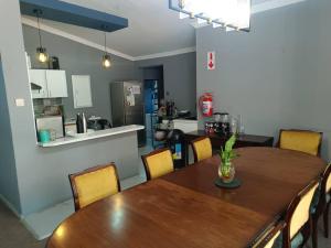 Un comedor con una mesa de madera y una cocina. en Guest On 97, en Gaborone 12 fotos más