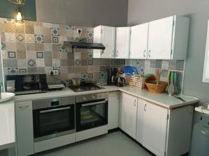 a kitchen with white cabinets and a stove top oven at Guest On 97 in Gaborone