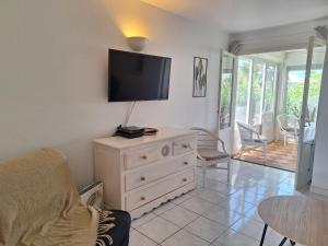 a living room with a dresser with a tv on the wall at Dolce Vita Anse Margot in Marigot