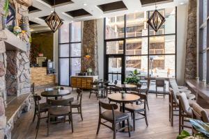a restaurant with tables and chairs and large windows at Westgate Resort- 1 BR, Resort Amenities, Shopping and Restaurants! in Park City