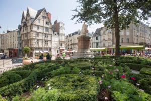 une place de la ville avec un jardin fleuri et des bâtiments dans l'établissement Kyriad Angers Ouest Beaucouzé, à Beaucouzé