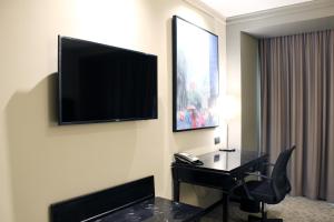 a hotel room with a desk and a television on a wall at Barceló Mexico Reforma in Mexico City