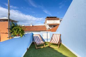 two chairs sitting on the balcony of a building at Casa Maria Amalia in Cascais