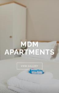 una pila di asciugamani su un letto con il testo esperimenti mamma di MDM APARTMENT CITY CENTER FELICITA DeLUXE a Ruse