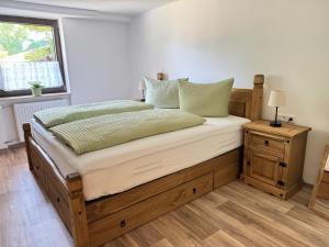 a bedroom with a wooden bed with a nightstand and a window at Ferienwohnung Alpenhirsch Schwangau in Schwangau