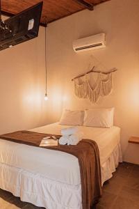 une chambre avec un lit avec deux serviettes dessus dans l'établissement FLATS COMFORT- Melhor CUSTOXBENEFÍCIO na charmosa Vila de São Jorge, Goiás, à Sao Jorge 56 autres photos