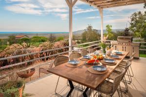 una mesa de madera con platos de comida en el patio en Villa Aura Boutique Escape with Heated Pool near Albena, en Rogachevo