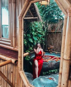 eine Frau in einem roten Kleid sitzt in einer Badewanne in der Unterkunft Penida Bambu Green Suites in Nusa Penida + 37 Fotos