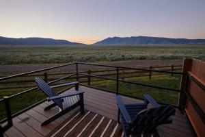 two chairs on a deck with a view of the desert at Red Rock RV Park in Island Park +10 photos