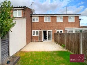 a brick house with a fence and a yard at Farnham - 2 Bedroom House - With Garden and Parking in Hale