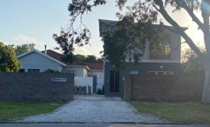 a white house with a fence and a driveway at Downstairs @38 in Port Elizabeth