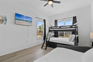 a bedroom with two bunk beds and a ceiling fan at Seas The Day in Navarre +55 photos