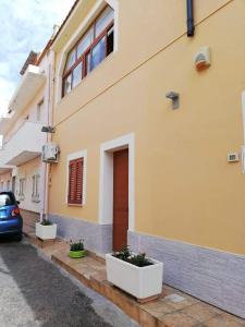 a building with a car parked in front of it at Appartamenti Vincenzo Lampedusa in Lampedusa