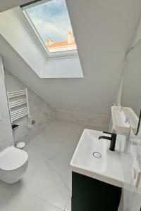 a bathroom with a skylight and a toilet and a sink at Cozy Paris Gateway Studio with free parking in Vitry-sur-Seine