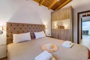 a bedroom with a large bed with two hats on it at Gkountis Deluxe King Suite 2 in Tsoukaladhes