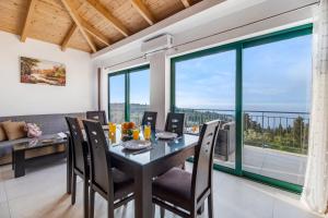 a dining room with a table and chairs and large windows at Gkountis Deluxe King Suite 2 in Tsoukaladhes