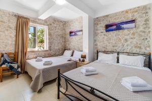 a bedroom with two beds and a window at Gkountis stone apartment 5 in Tsoukaladhes +19 photos