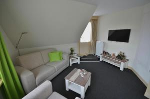 a living room with a couch and a tv at Westenwind in Egmond aan Zee