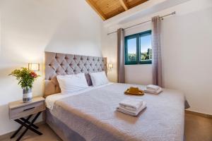 een slaapkamer met een groot bed met handdoeken erop bij Gkountis Deluxe King Suite 1 in Tsoukaladhes