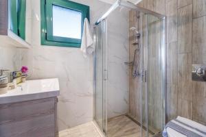 een badkamer met een glazen douche en een wastafel bij Gkountis Deluxe King Suite 1 in Tsoukaladhes +20 foto's