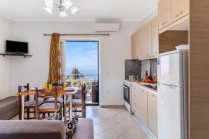 a kitchen with a table and a dining room with a view at Gkountis deluxe apartment in Tsoukaladhes