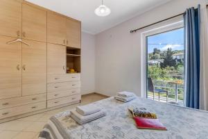 a bedroom with a bed and a large window at Gkountis deluxe apartment in Tsoukaladhes