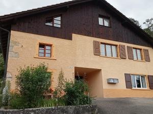 a house with a brown roof and windows at Studio 2 personnes tout équipé in Glovelier