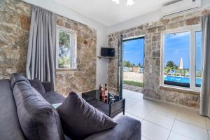a living room with a couch and a large window at Gkountis stone apartment 3 in Tsoukaladhes