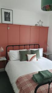 a bedroom with a large bed with a red headboard at City Cottage in Lincoln