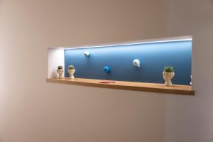 a mirror on a wall with three vases on a shelf at Dimora Delle Vigne in Andria