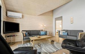 a living room with couches and a flat screen tv at Amazing Home In Tarm With Sauna in Tarm