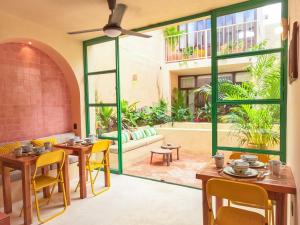 梅里达Kuka y Milpa的一家餐厅,里面有桌椅和一个大窗户。